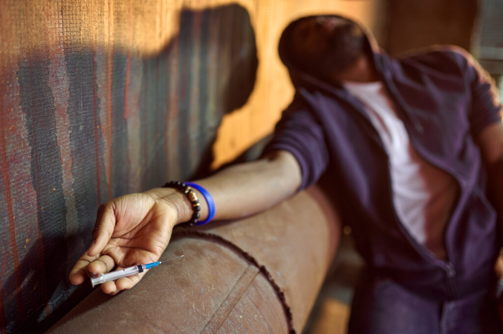 drug addict man with syringe in high